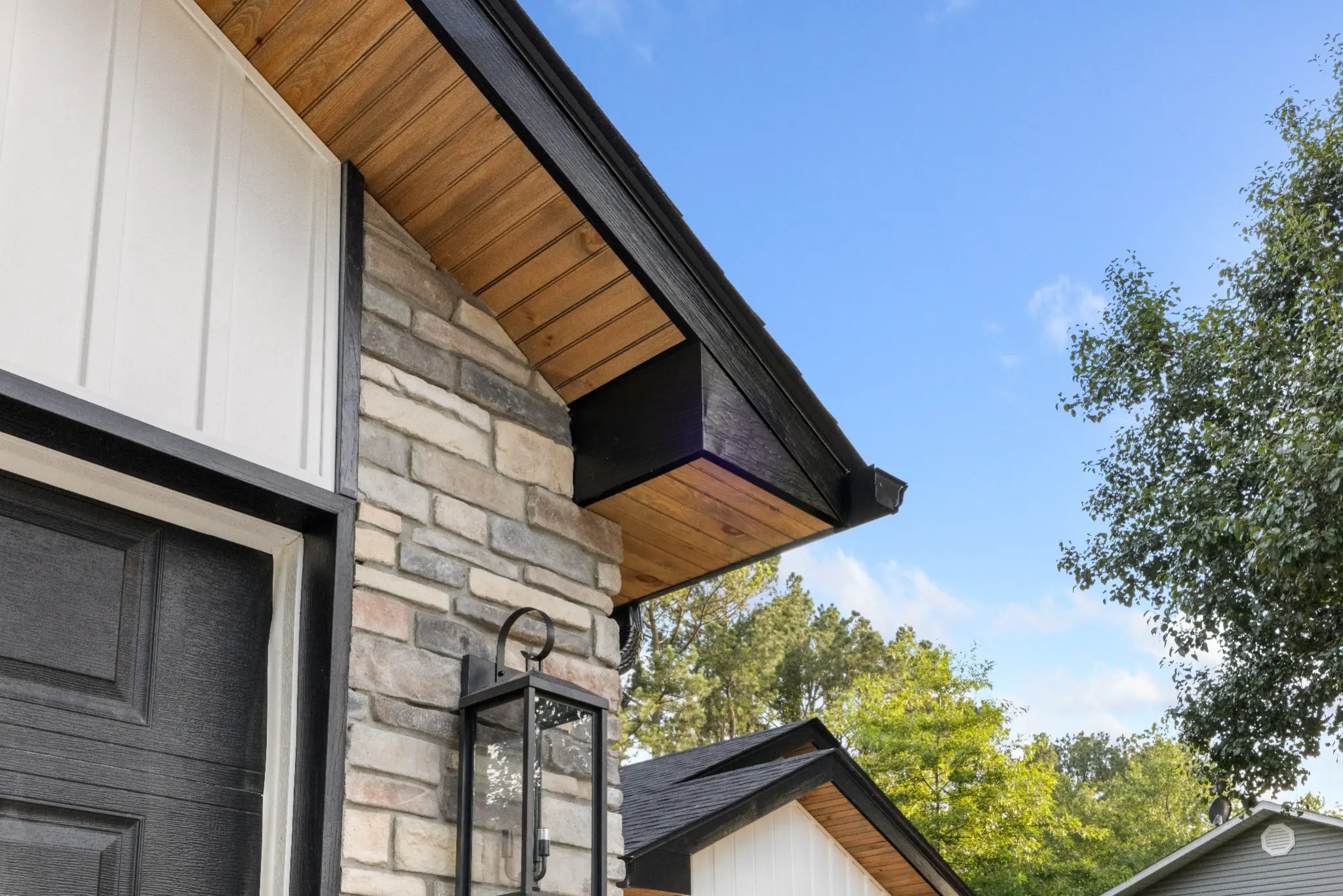 Stonework, wood soffit, and black trim on a completed Wright Homes build